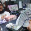Warga melakukan penukaran mata uang rupiah ke dolar AS di Money Changer Jakarta