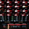 Karyawan di depan layar pergerakan harga saham IHSG di Bursa Efek Indonesia