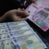 Karyawan menghitung uang pecahan dolar AS di gerai penukaran mata uang asing Jakarta